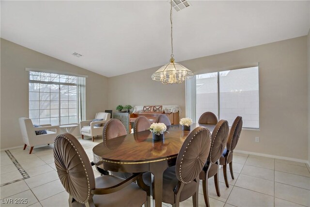 dining space with plenty of natural light, lofted ceiling, and light tile patterned floors