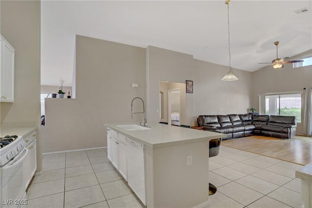 kitchen featuring light countertops, light tile patterned floors, a sink, and white appliances