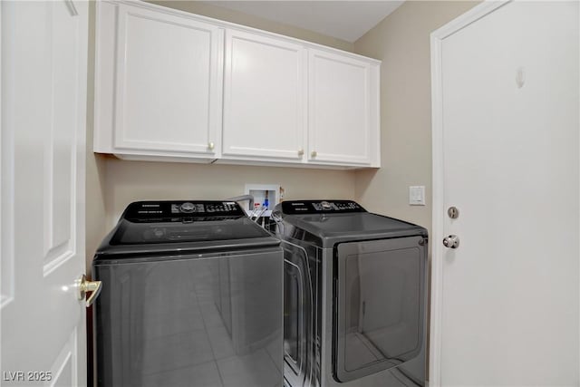 washroom featuring cabinet space and washer and clothes dryer