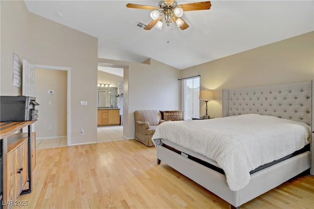 bedroom with baseboards, connected bathroom, visible vents, and light wood-style floors
