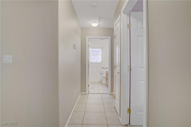 hallway with light tile patterned flooring and baseboards