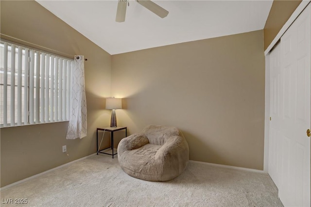 living area featuring vaulted ceiling, carpet, and a ceiling fan