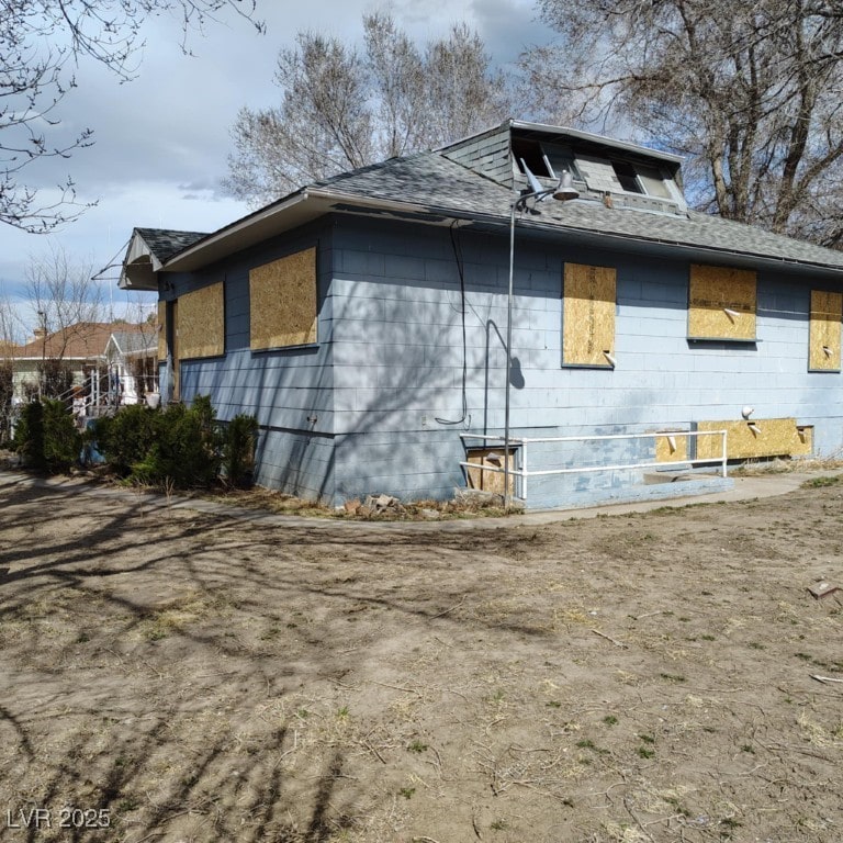 view of side of property with a shingled roof