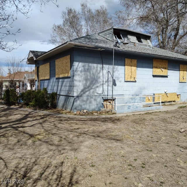 view of side of property with a shingled roof