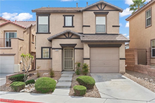 view of front of house with driveway, stucco siding, a tiled roof, and an attached garage