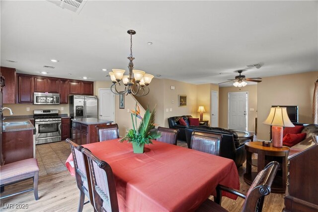 dining area with ceiling fan with notable chandelier, light wood finished floors, visible vents, and recessed lighting