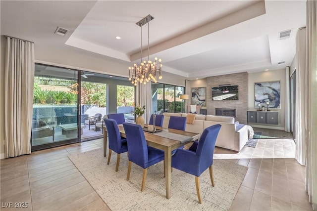 10 Sugarberry Ln, Las Vegas, NV 89135 - dining room with a raised ceiling, a chandelier, tile patterned floors, and a large fireplace