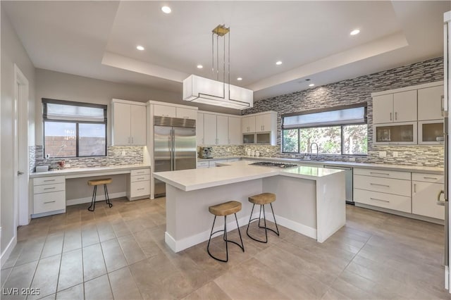 10 Sugarberry Ln, Las Vegas, NV 89135 - kitchen with appliances with stainless steel finishes, a raised ceiling, backsplash, a breakfast bar, and recessed lighting