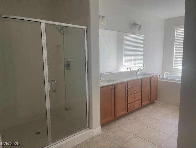 bathroom featuring a sink, tile patterned floors, a shower stall, and a garden tub