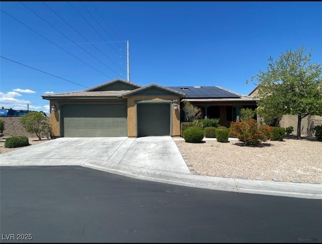 single story home with a garage, concrete driveway, and solar panels