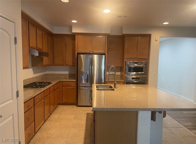 kitchen with appliances with stainless steel finishes, a sink, light tile patterned floors, under cabinet range hood, and recessed lighting