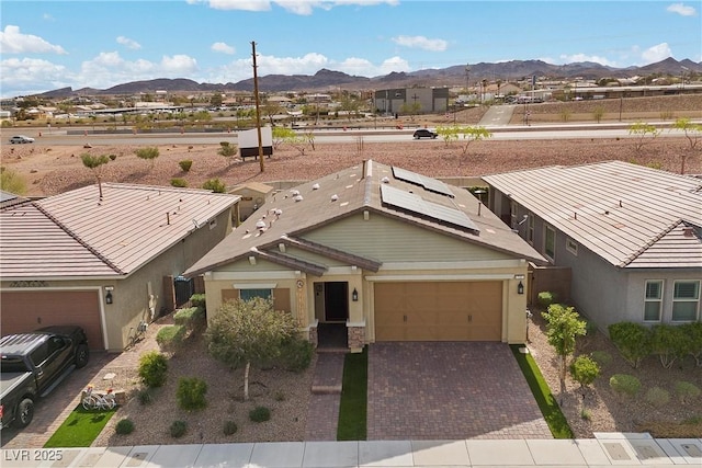 732 Rosewater Dr, Henderson, NV 89011 - view of front of home with a mountain view, a garage, decorative driveway, solar panels, and stucco siding