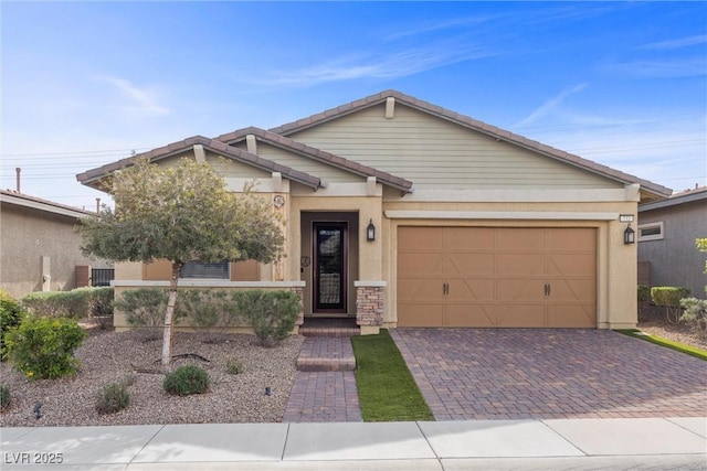 732 Rosewater Dr, Henderson, NV 89011 - view of front of home featuring decorative driveway, an attached garage, stucco siding, a tile roof, and stone siding