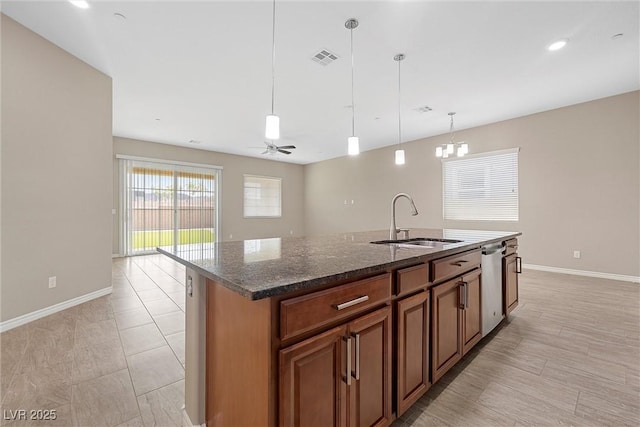 732 Rosewater Dr, Henderson, NV 89011 - kitchen with a sink, stainless steel dishwasher, baseboards, an island with sink, and dark stone countertops