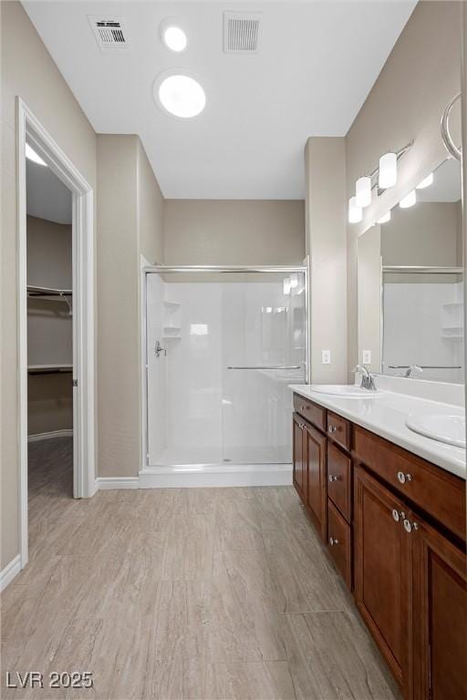732 Rosewater Dr, Henderson, NV 89011 - full bath featuring a stall shower, double vanity, a walk in closet, wood finished floors, and baseboards
