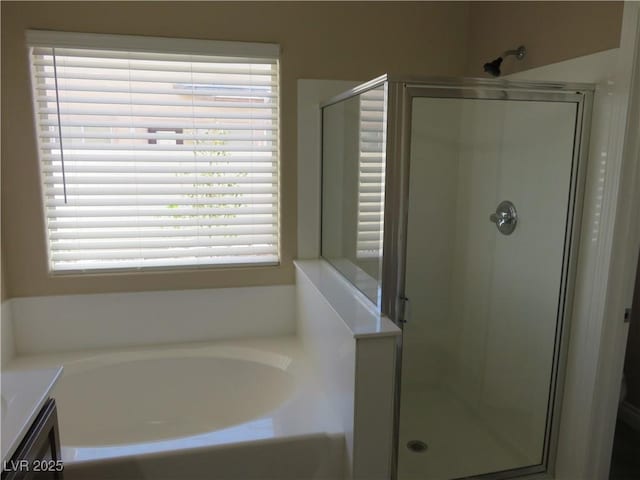 bathroom featuring plenty of natural light, a stall shower, and a garden tub