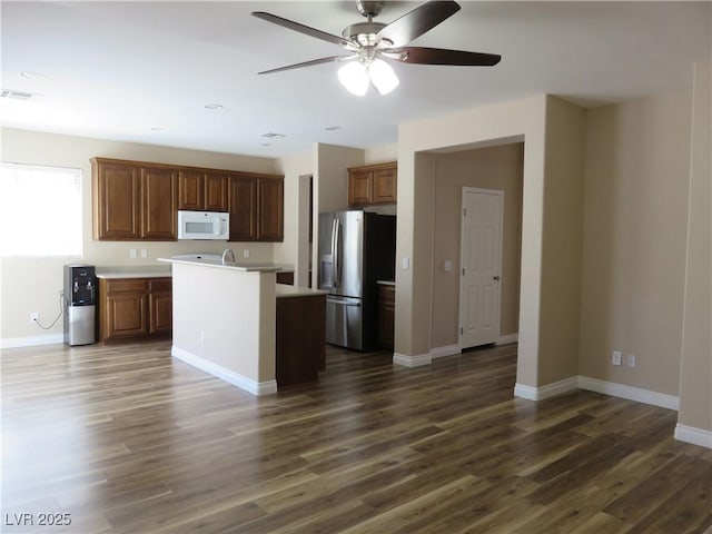 kitchen featuring light countertops, stainless steel refrigerator with ice dispenser, ceiling fan, visible vents, and white microwave