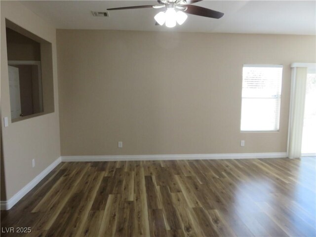 empty room with baseboards, ceiling fan, and wood finished floors