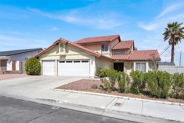 mediterranean / spanish home with a tile roof, stucco siding, a garage, and driveway
