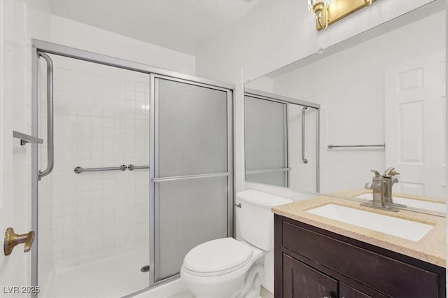 bathroom with vanity, toilet, and a shower stall