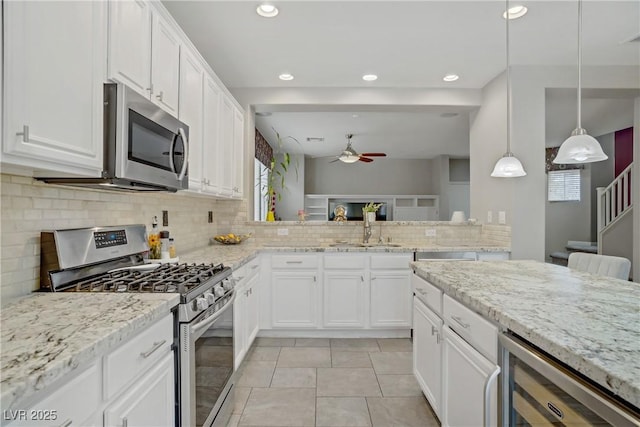 651 Penshaw Bridge Ave, Las Vegas, NV 89178 - kitchen featuring appliances with stainless steel finishes, wine cooler, a ceiling fan, backsplash, and white cabinetry