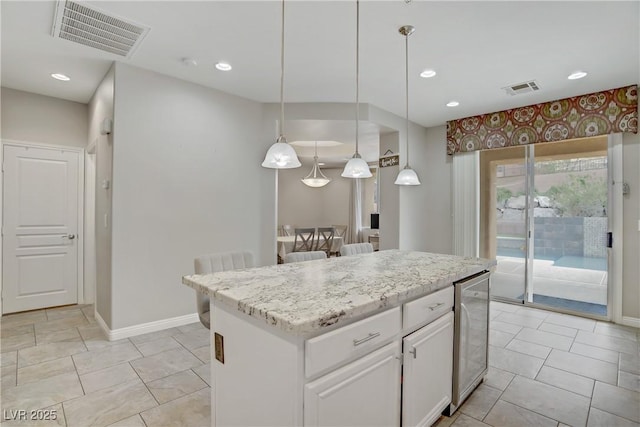 651 Penshaw Bridge Ave, Las Vegas, NV 89178 - kitchen with white cabinetry, a kitchen island, beverage cooler, recessed lighting, and hanging light fixtures