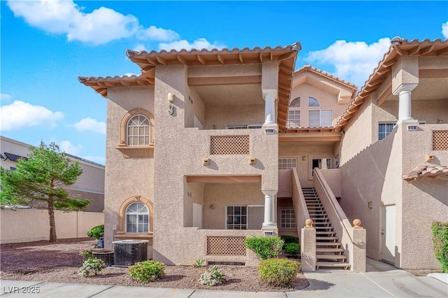 2925 Wigwam Pkwy Unit 312, Henderson, NV 89074 - view of front facade featuring cooling unit, stucco siding, and stairs