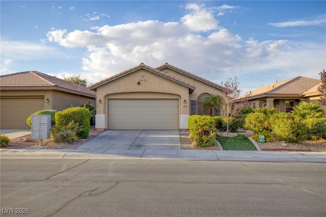 mediterranean / spanish house with a garage, driveway, a tile roof, and stucco siding