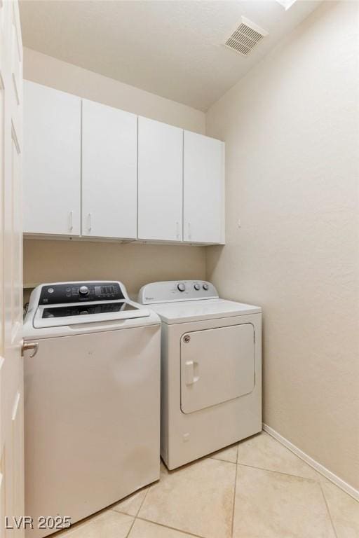 laundry room featuring washing machine and clothes dryer, cabinet space, baseboards, light tile patterned floors, and visible vents