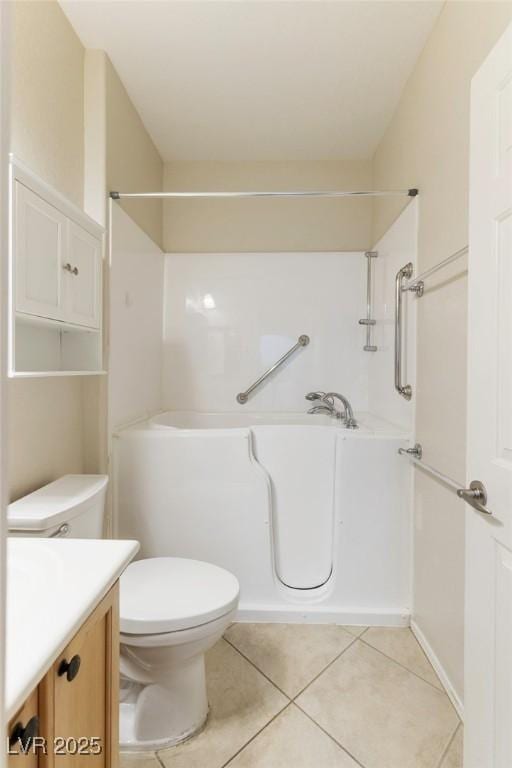 bathroom featuring vanity, a bathtub, tile patterned floors, and toilet