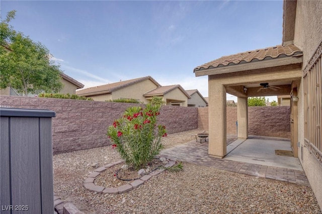 view of yard featuring a patio, ceiling fan, and a fenced backyard