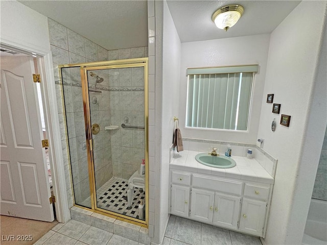 full bathroom featuring tile patterned flooring, a stall shower, and vanity