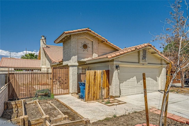 view of front of property with a tile roof, fence, concrete driveway, an attached garage, and stucco siding