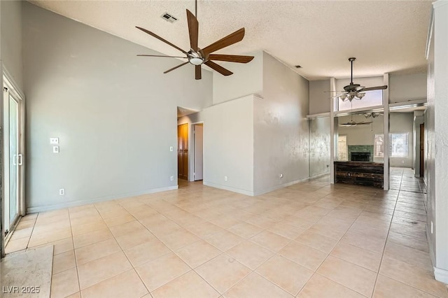 unfurnished living room featuring high vaulted ceiling, a ceiling fan, light tile patterned flooring, and visible vents