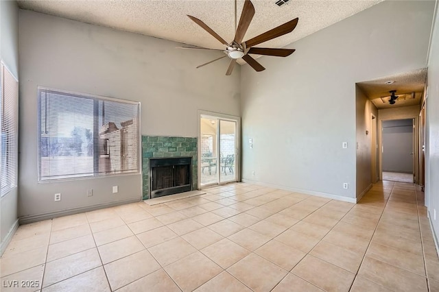 unfurnished living room featuring a ceiling fan, a textured ceiling, light tile patterned flooring, and high vaulted ceiling