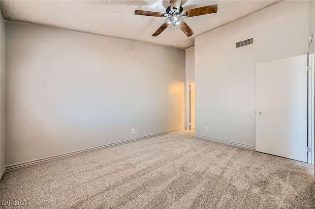 unfurnished room featuring carpet flooring, a ceiling fan, a textured ceiling, and visible vents