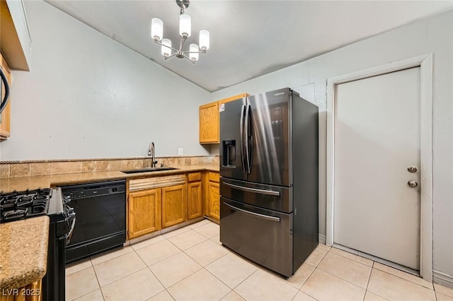 kitchen featuring an inviting chandelier, lofted ceiling, light countertops, a sink, and black appliances