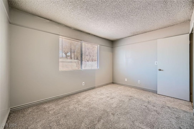 carpeted empty room with a textured ceiling