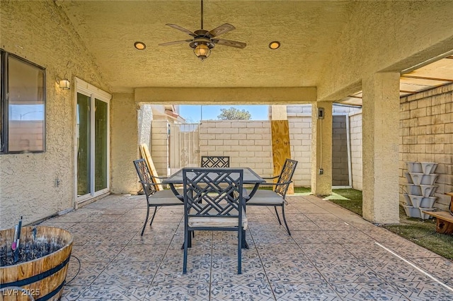 view of patio with a fenced backyard, a ceiling fan, and outdoor dining space