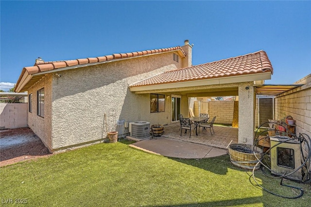 back of house featuring a fenced backyard, central air condition unit, stucco siding, and a yard
