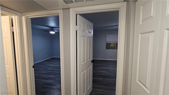 corridor featuring baseboards and wood finished floors