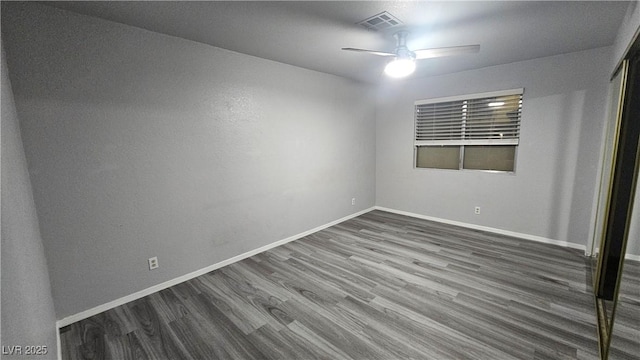 spare room with ceiling fan, baseboards, dark wood-type flooring, and visible vents