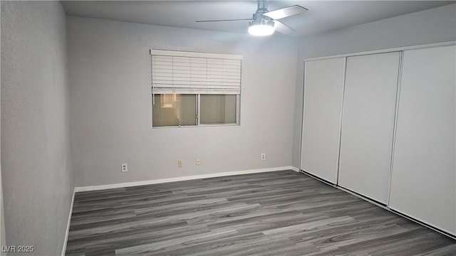 unfurnished bedroom with ceiling fan, baseboards, wood finished floors, and a closet