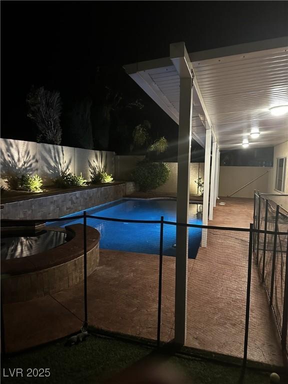 pool at twilight featuring a fenced in pool and a patio area