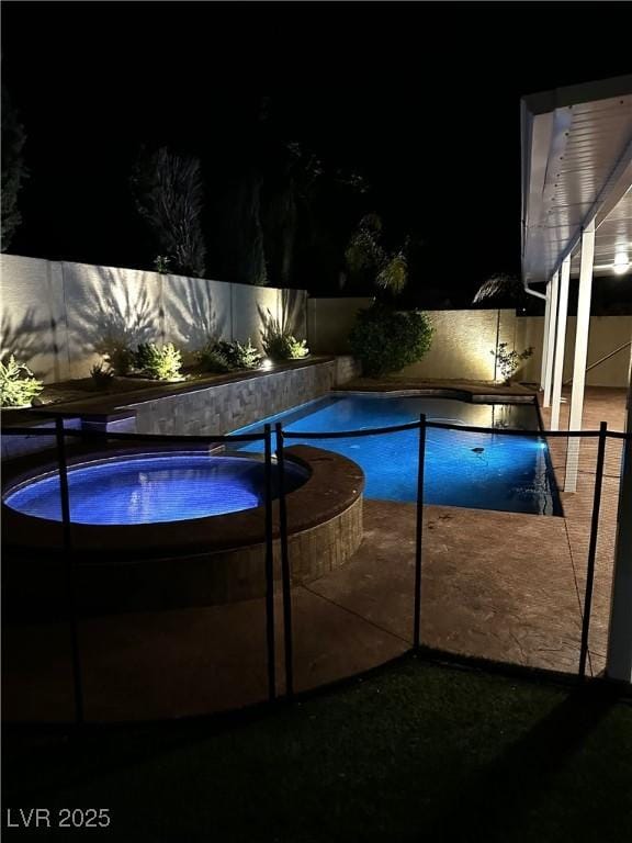 pool at twilight featuring fence, an in ground hot tub, and a fenced in pool