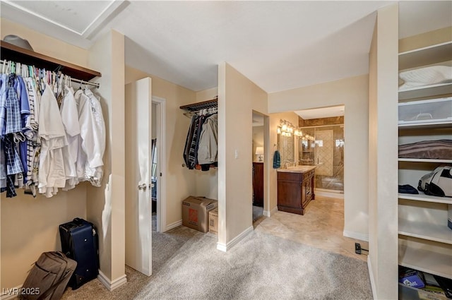 walk in closet with an inviting chandelier and a sink