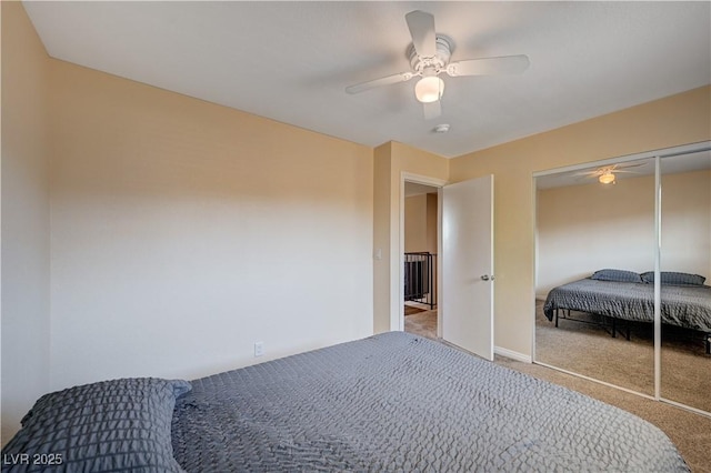 carpeted bedroom with ceiling fan, baseboards, and a closet