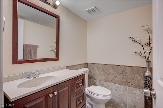 bathroom with visible vents, toilet, and vanity