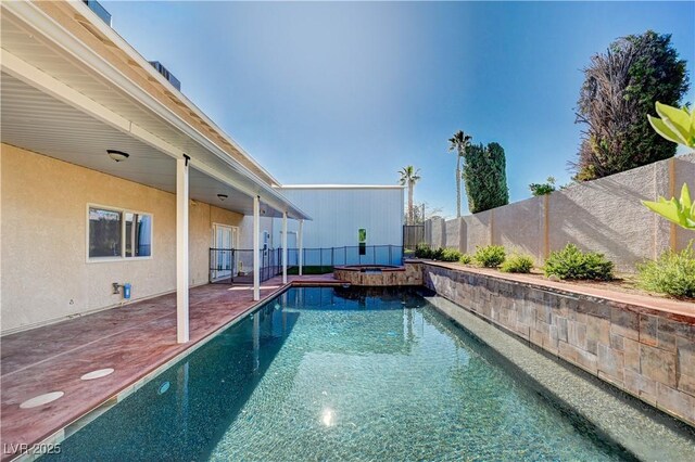 view of swimming pool featuring a pool with connected hot tub, a fenced backyard, and a patio area