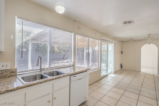 kitchen featuring light countertops, dishwasher, visible vents, a sink, and light tile patterned flooring